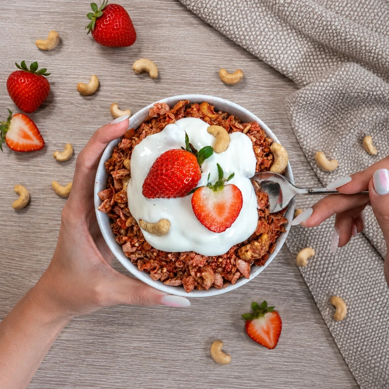 Domowa granola z jogurtem, truskawkami i orzechami nerkowca